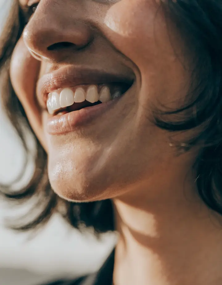 A relaxed smile in soft natural light, lower face only