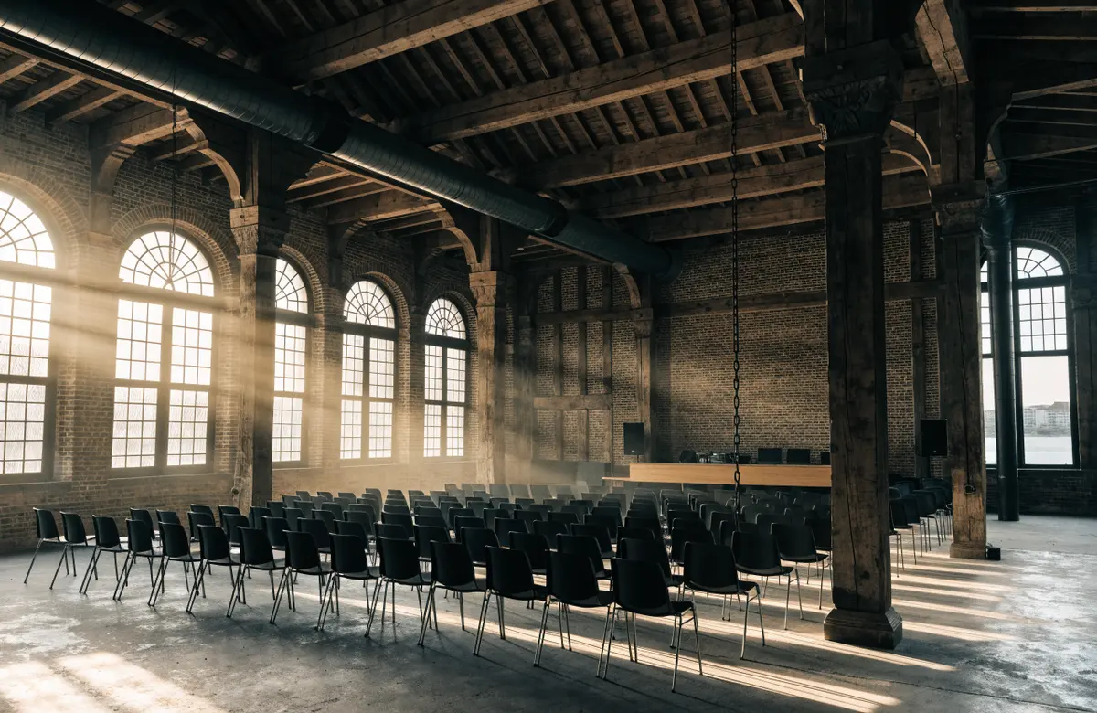 The main hall in Riverbank Hall, set with rows of chairs under arched windows