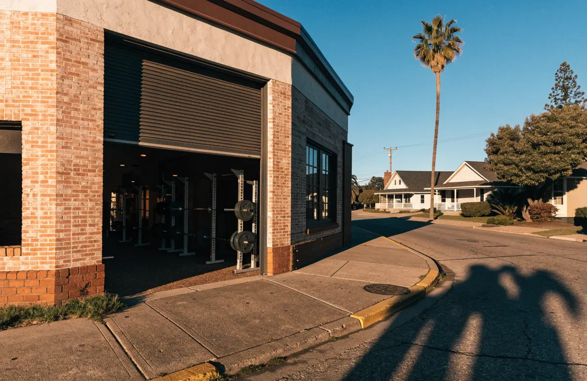 The open roll-up door of the gym on a sunny North Park street