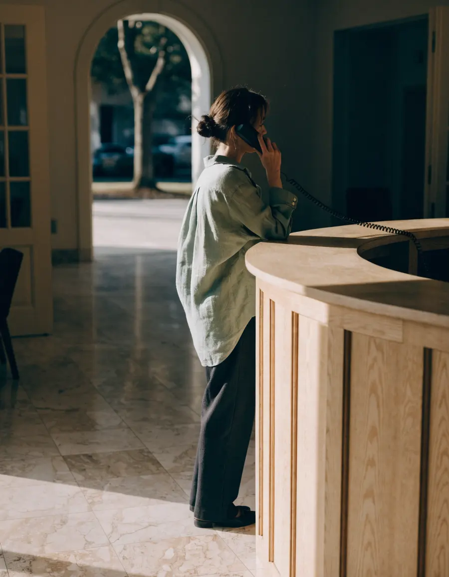 Lena, the front desk coordinator, on the phone