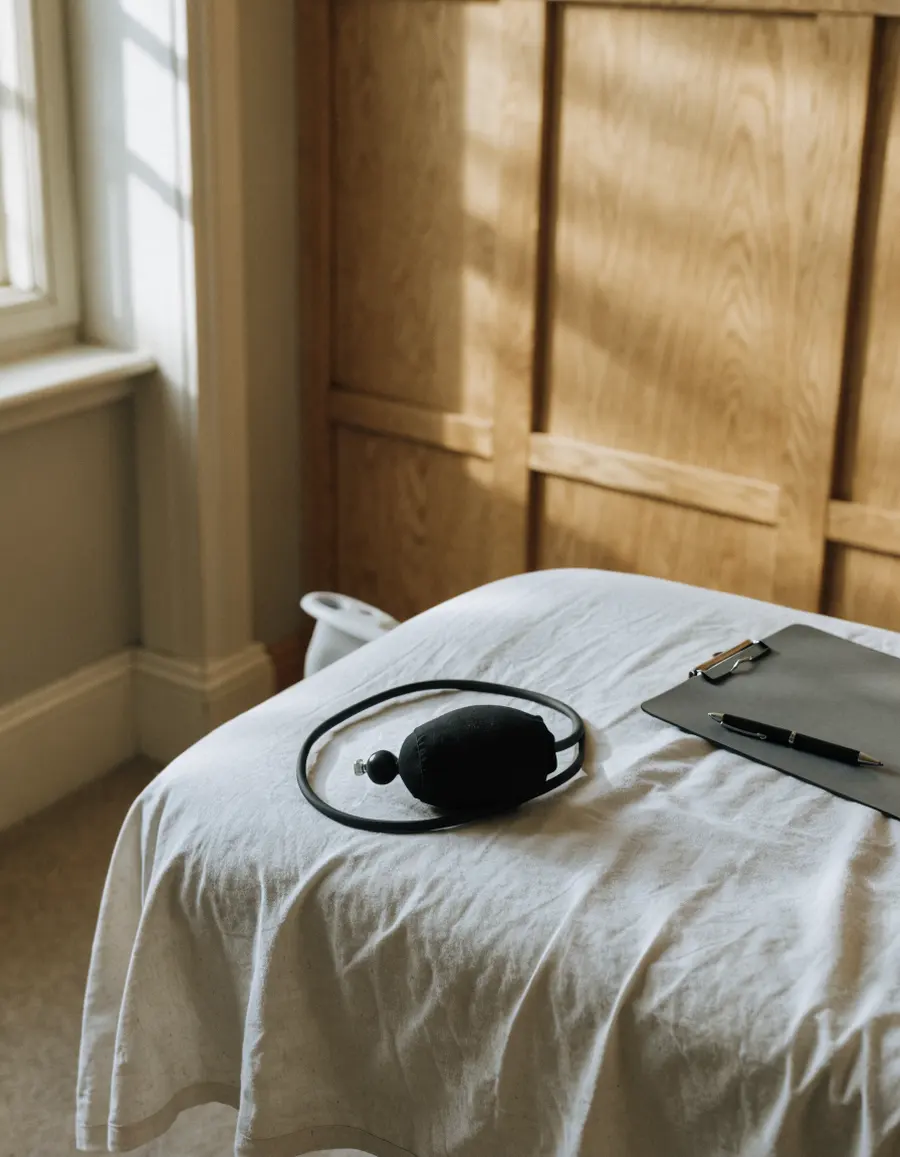 A blood pressure cuff and a pen on a treatment bed