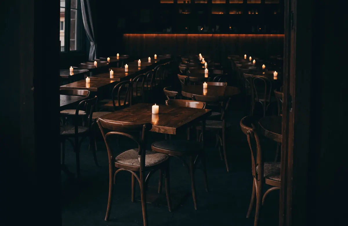 The dining room at night, a candle lit on every table