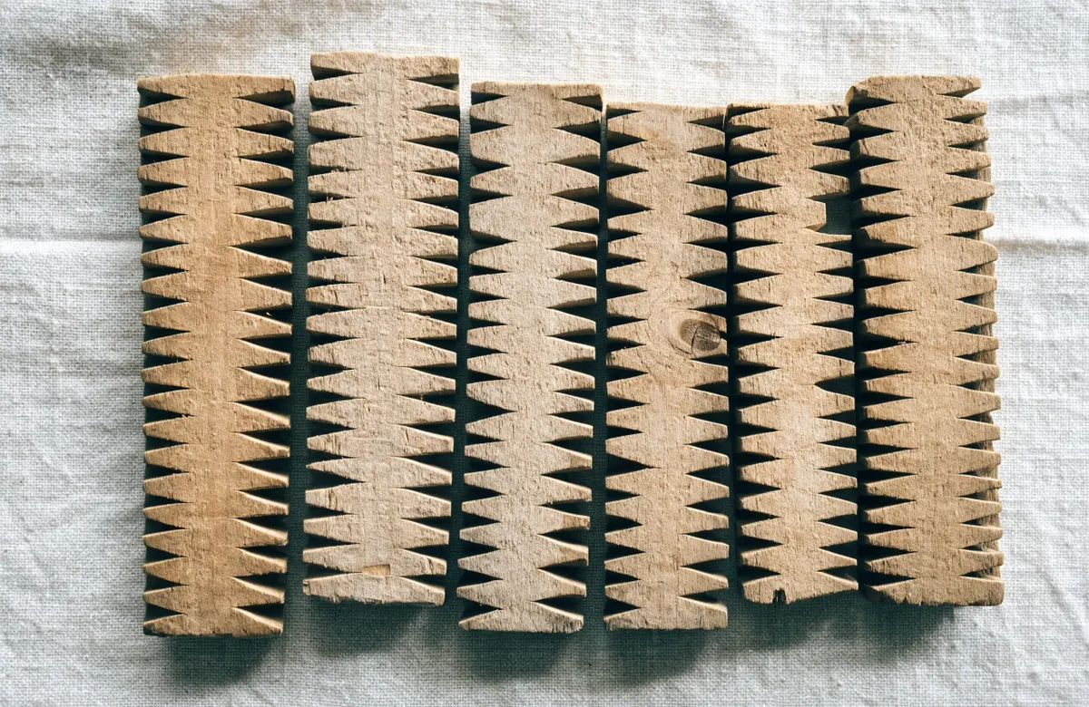 Old notched wooden tally sticks laid side by side on linen